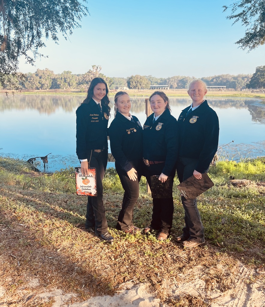Students wearing FFA Jackets  pose in front of a body of water.