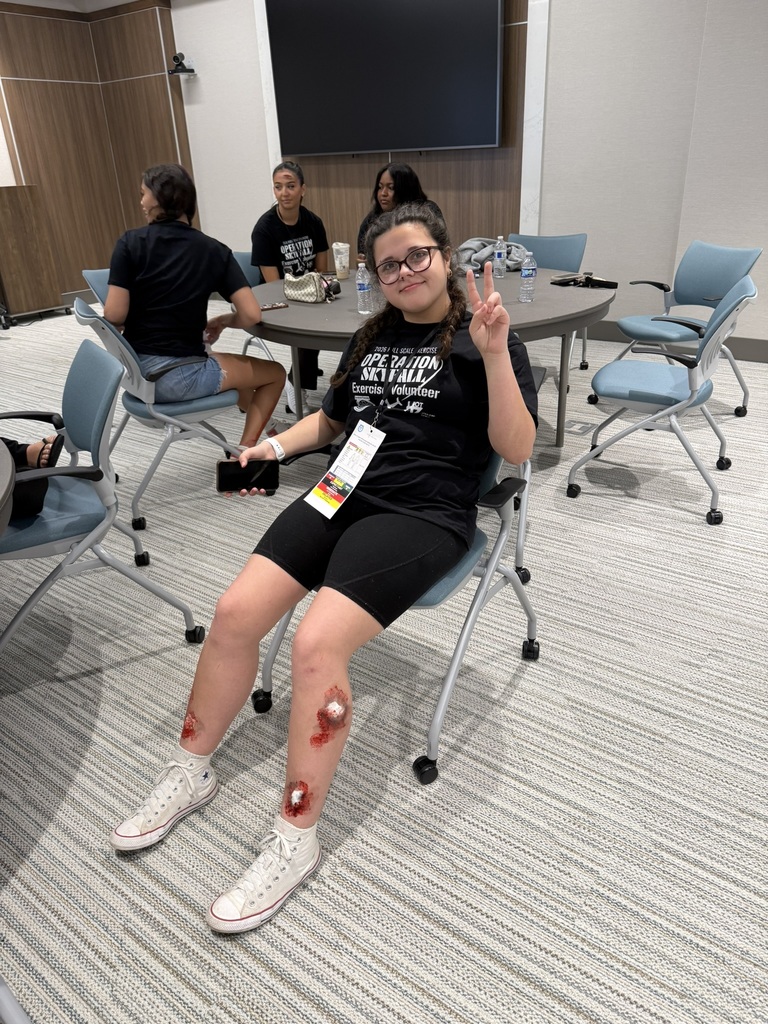 Student enactor with fake wounds ono her legs poses in a chair