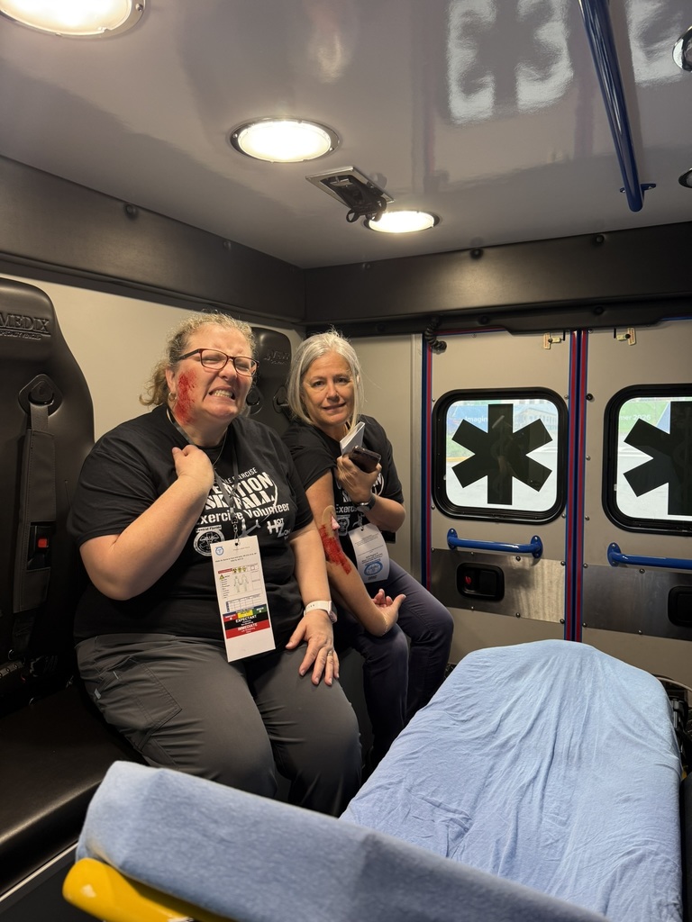 2 staff enactors pose in an abulance with fake wounds on their face and arms