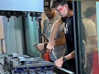 Student wearing goggles and working with machinery