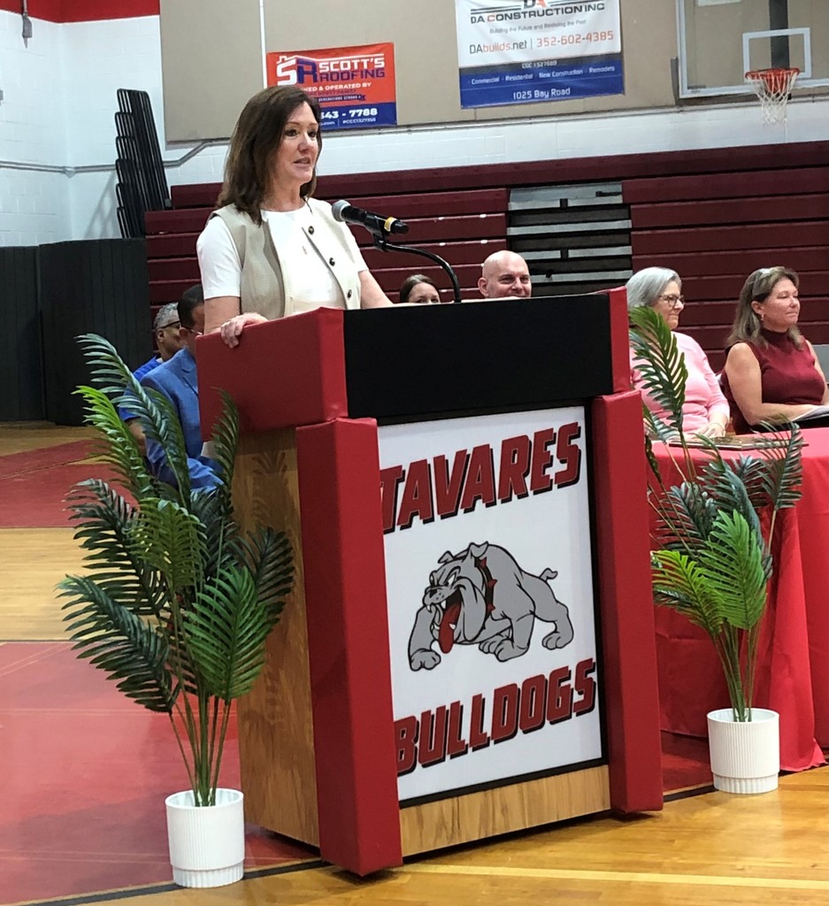 Superintendent Kornegay standing behind podium that bears Tavares High logo
