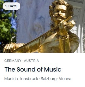 A golden statue of a man playing a violin. A sign with "The Sound of Music" and destinations Munich, Innsbruck, Salzburg, Vienna.
