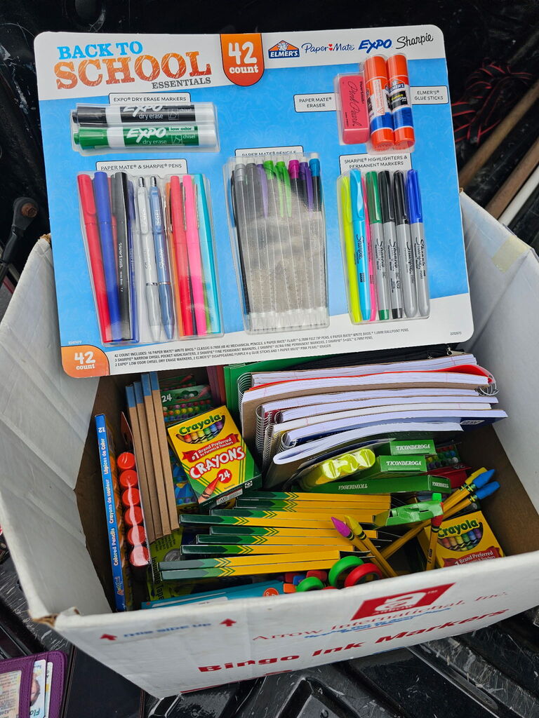 Box full of school supplies, including pens, pencils, markers, notebooks, and crayons. Cover says "Back to School 42".