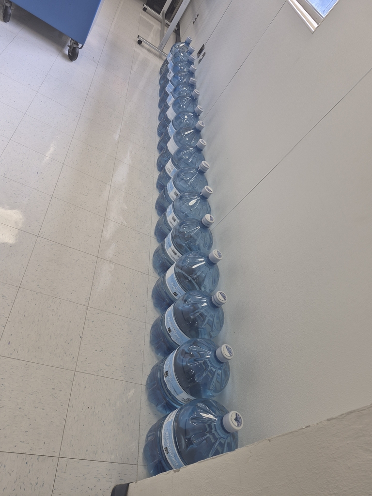Watet jugs lined up, ready to be put into the dispenser. 