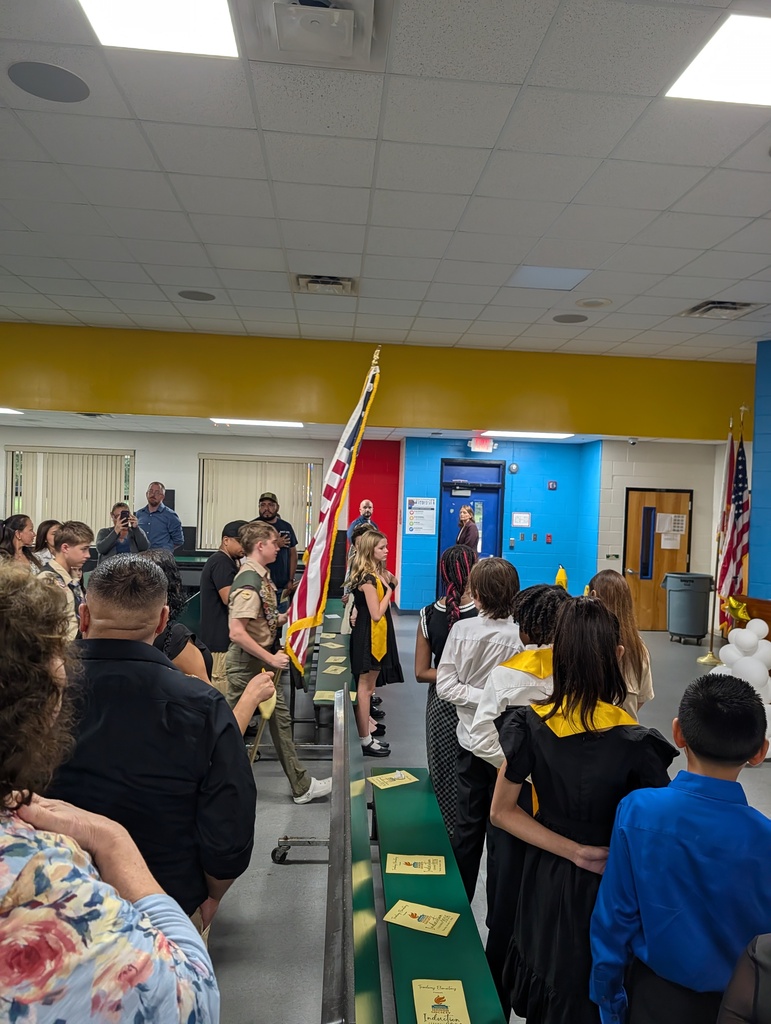 A scout walks down the aisle to present the flag for the pledge