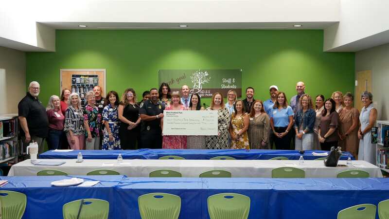 Large group holding display check of $17,624 made out to Fruitland Park Elementary School from Bless Fruitland Park