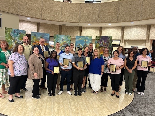Middle and high school principals posed holding plaques