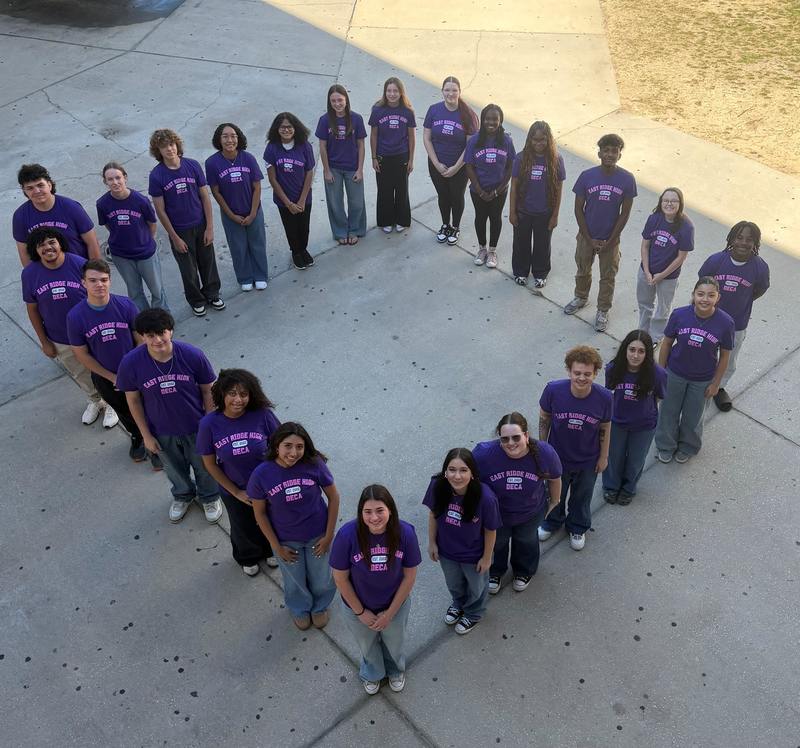 students in purple T-shirts standing in a diamond shape