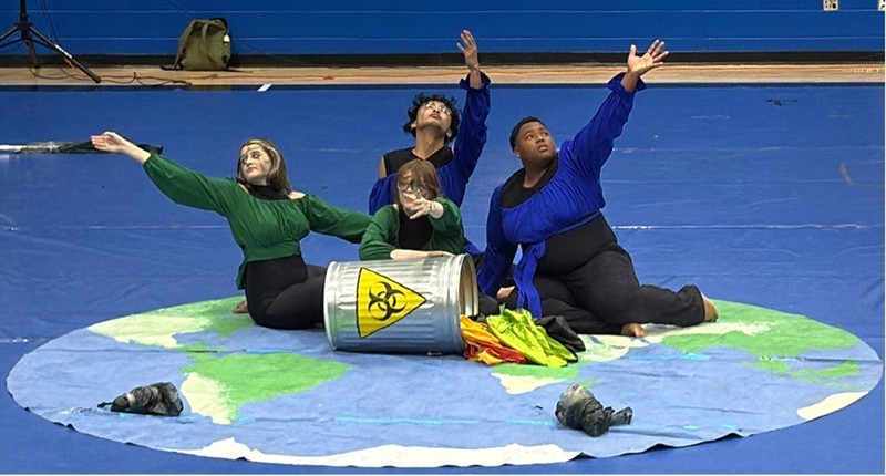Four winterguard performance seated in pose