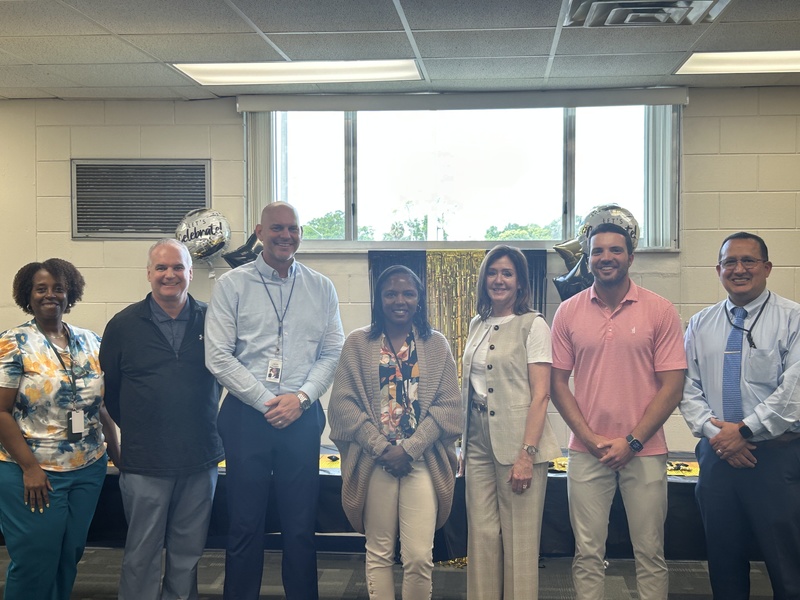Reshonda Scott posed with senior staff and School Board member Tyler Brandeburg