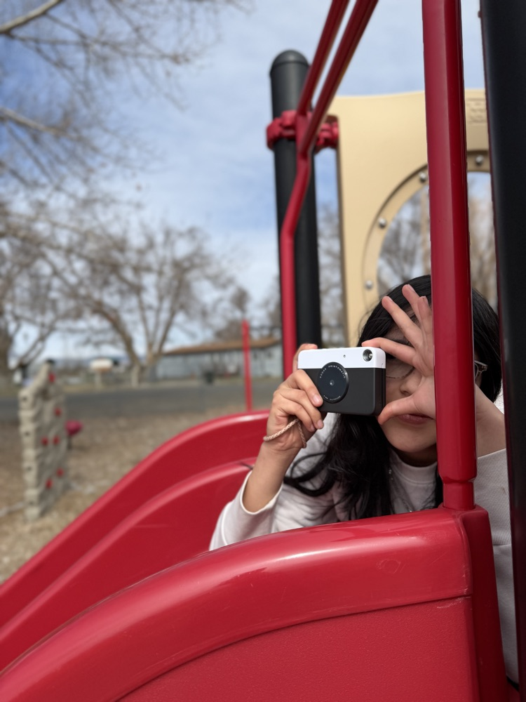 girl on slide taking photo 