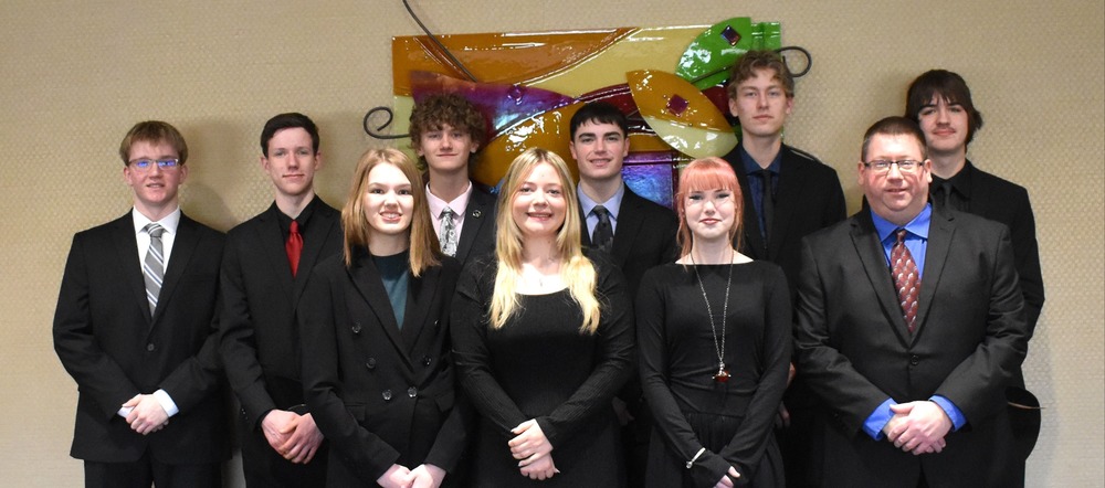 students lined up, dressed nicely, smiling at camera. 