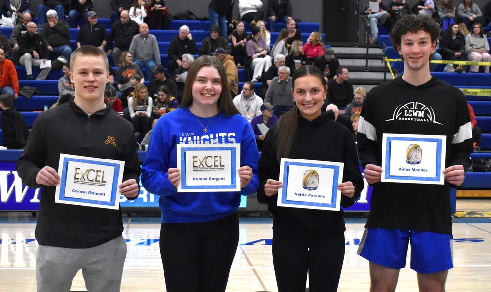 Four students holding certificates lined up, smiling at camera. 