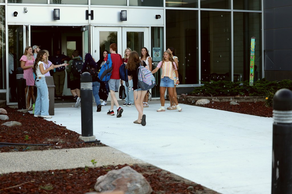 students greeting students as they walk in. 