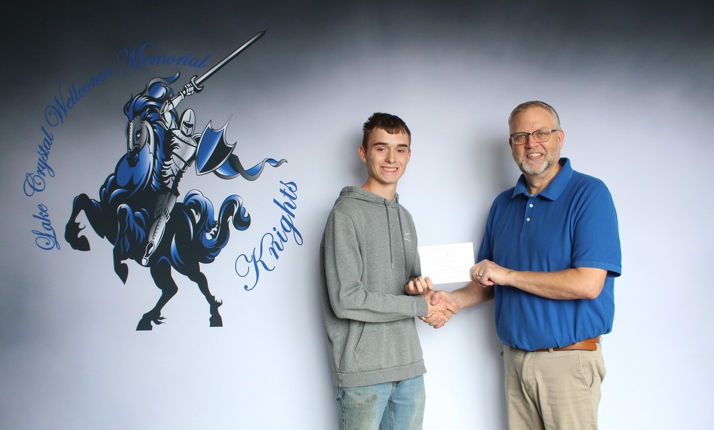 Photo of secondary principal Mike Thofson, shaking hands with Tyler, presenting him the award.