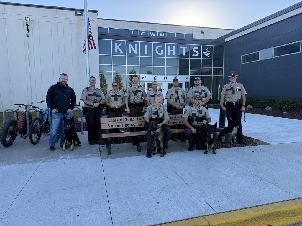 Local law enforcement posing with K-9 units outside of the school building after conducting the drills.