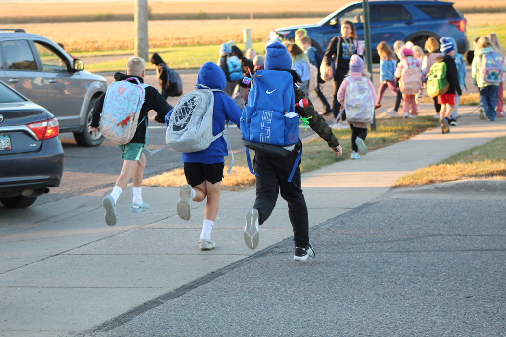 Students running to catch up to a group, walking to school.