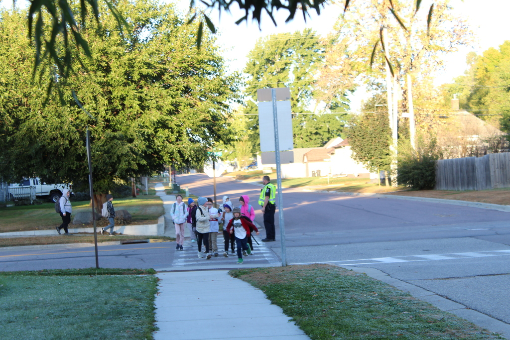 students crossing the street with the help of local law enforcement.