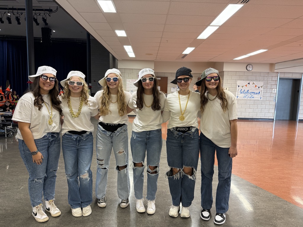 Students dressed up in white shirts and hats and blue jeans. 
