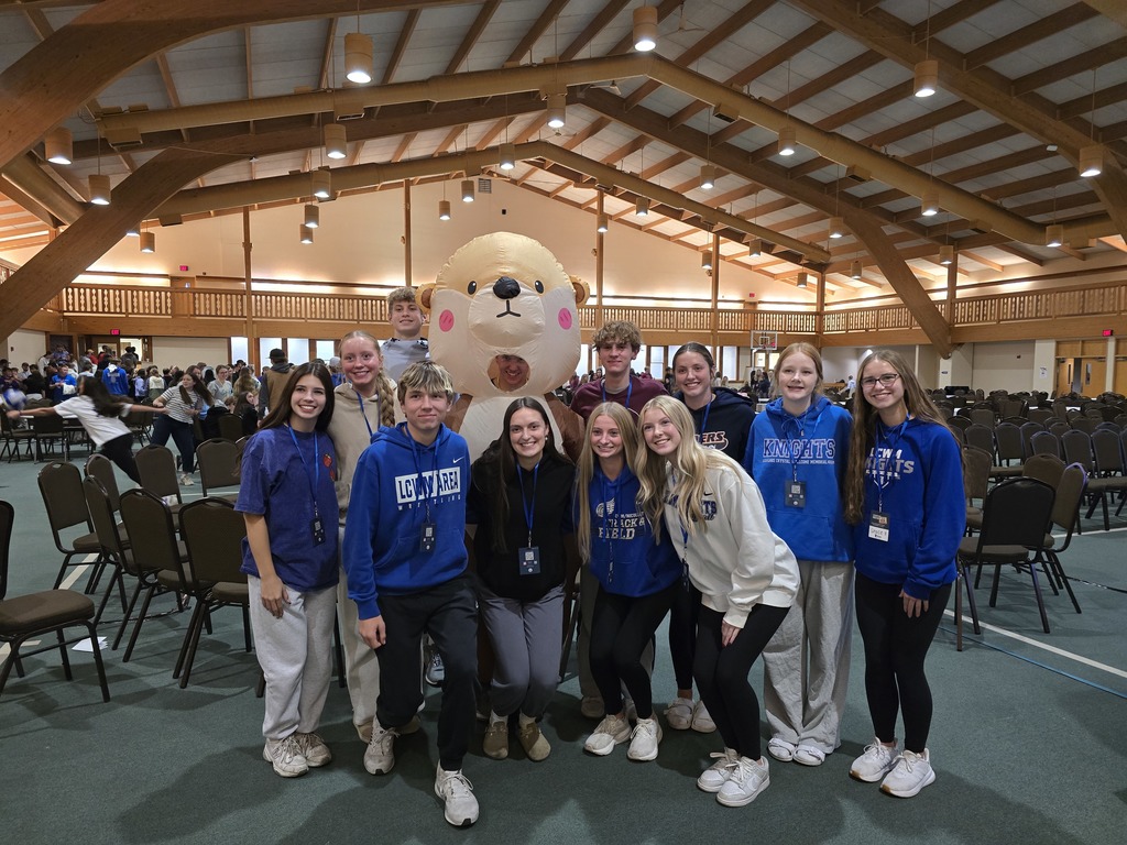 Students posing and smiling in an event center room.