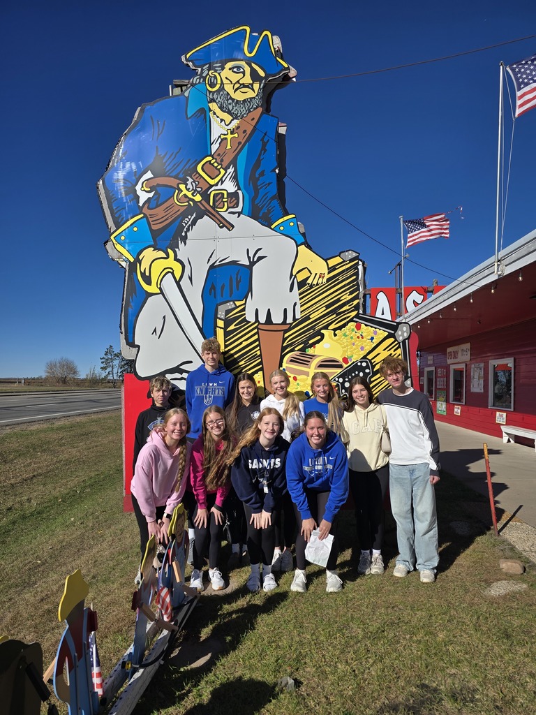 Students posing in front of the "Treasure City" pirate sign.