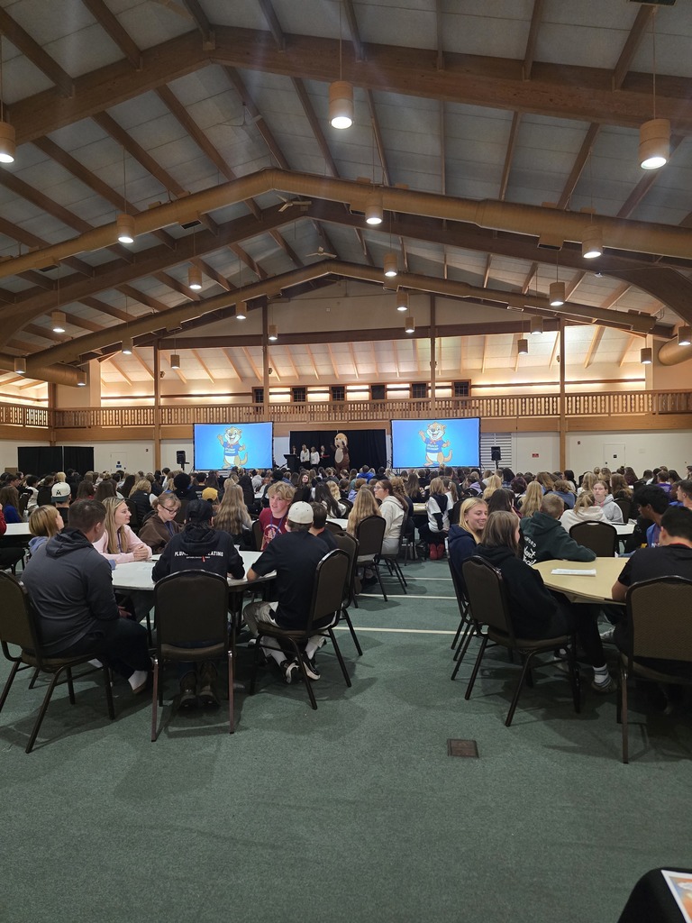 students sitting at tables listening to speakers.