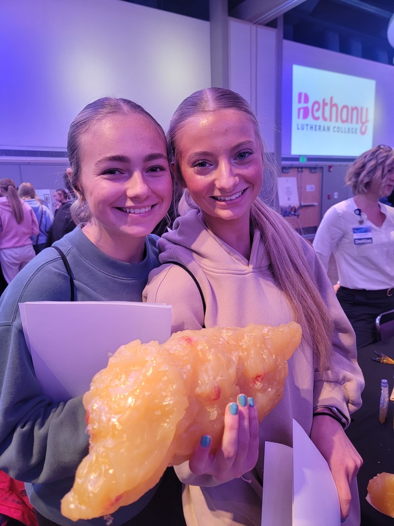 Two students holding a replica of fat.