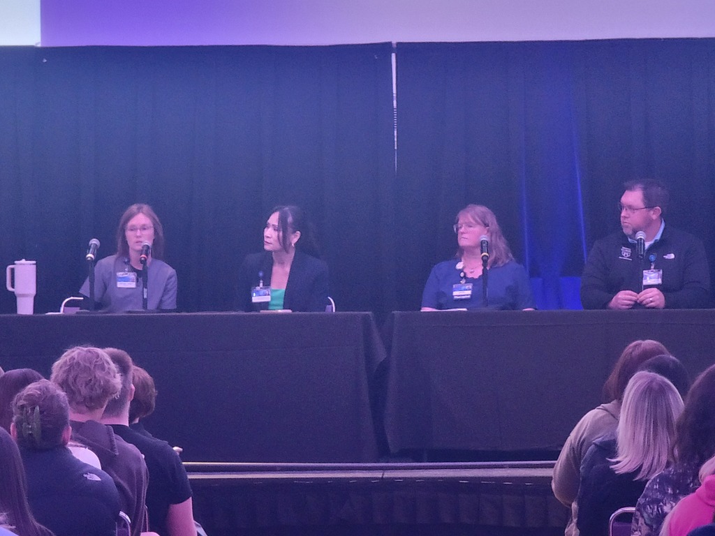 Panel of medical professionals on stage.