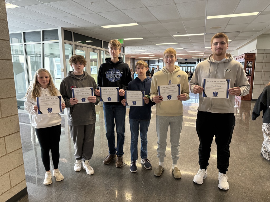 November students of the month standing in a line holding their certificates