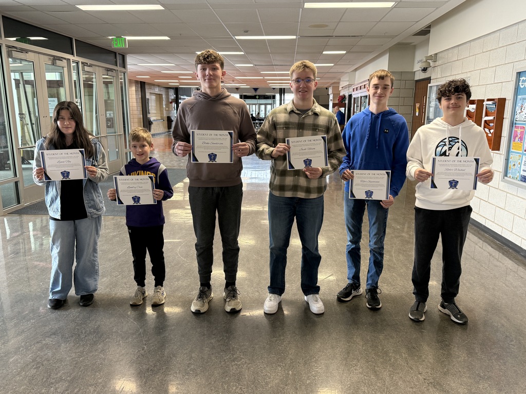 Students in a line holding their certificates for being recognized for the December students of the month. 