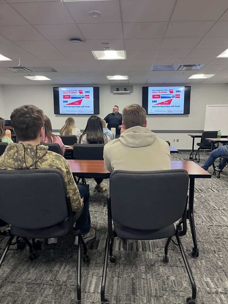 Students in a classroom setting learning about driving semi for a living.