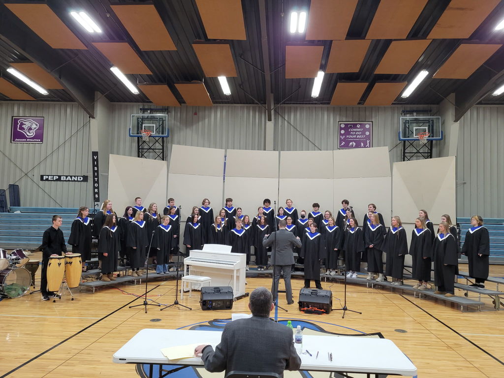 choir performing in front of one judge standing on risers. 