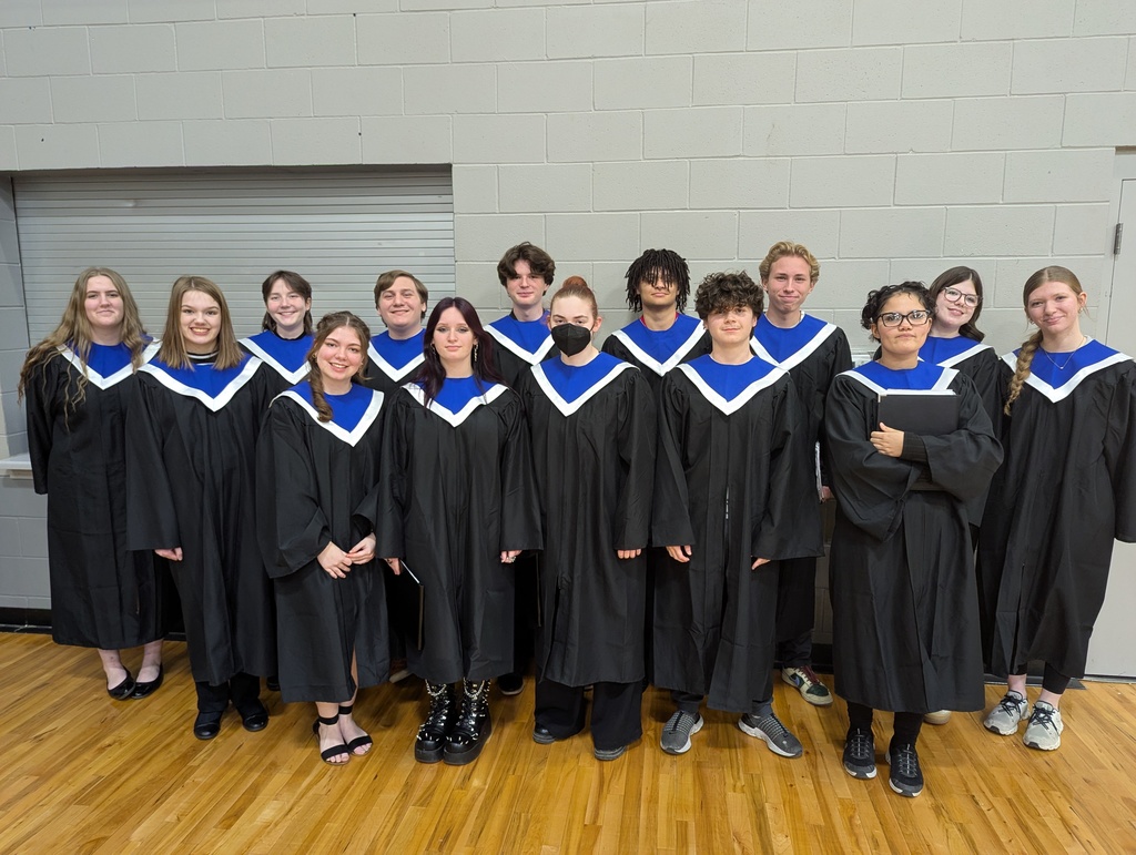 Honor choir students standing in their choir robes looking at the camera. 