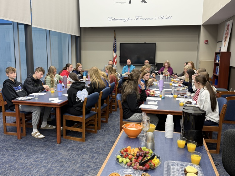achool board and student council members eating breakfast items together while they talked  