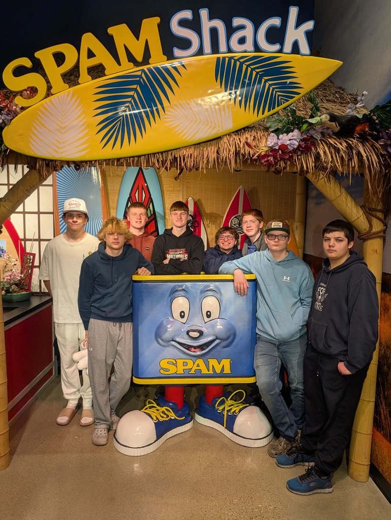 Students posing with a large can of spam at the spam museum. 