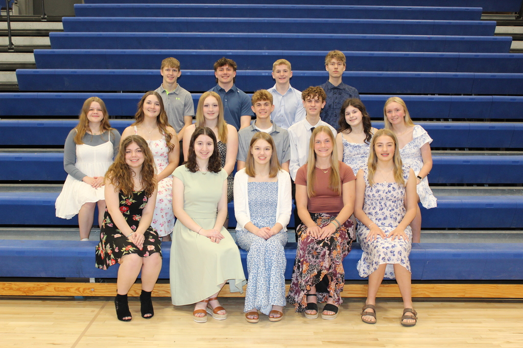 First year NHS Inducted members sitting in the bleachers smiling at camera.