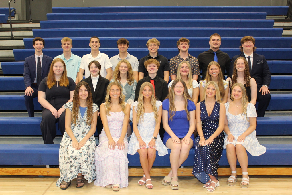 Third year NHS Inducted members sitting in the bleachers smiling at camera.