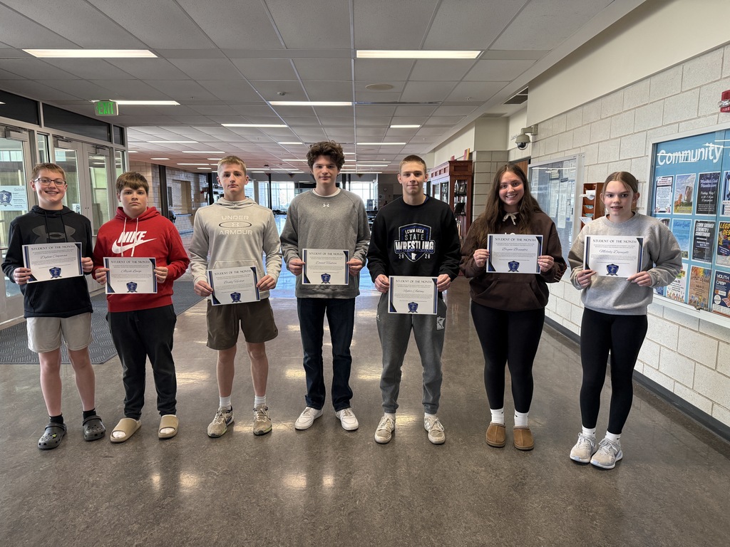 Students standing in a line holding certificates 