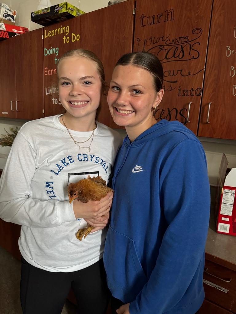 Student holding chicken in classroom. 
