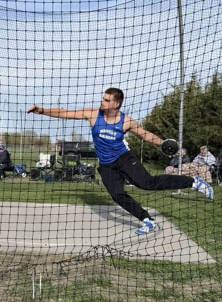 Drew Turgeon throwing discus in the cage. 
