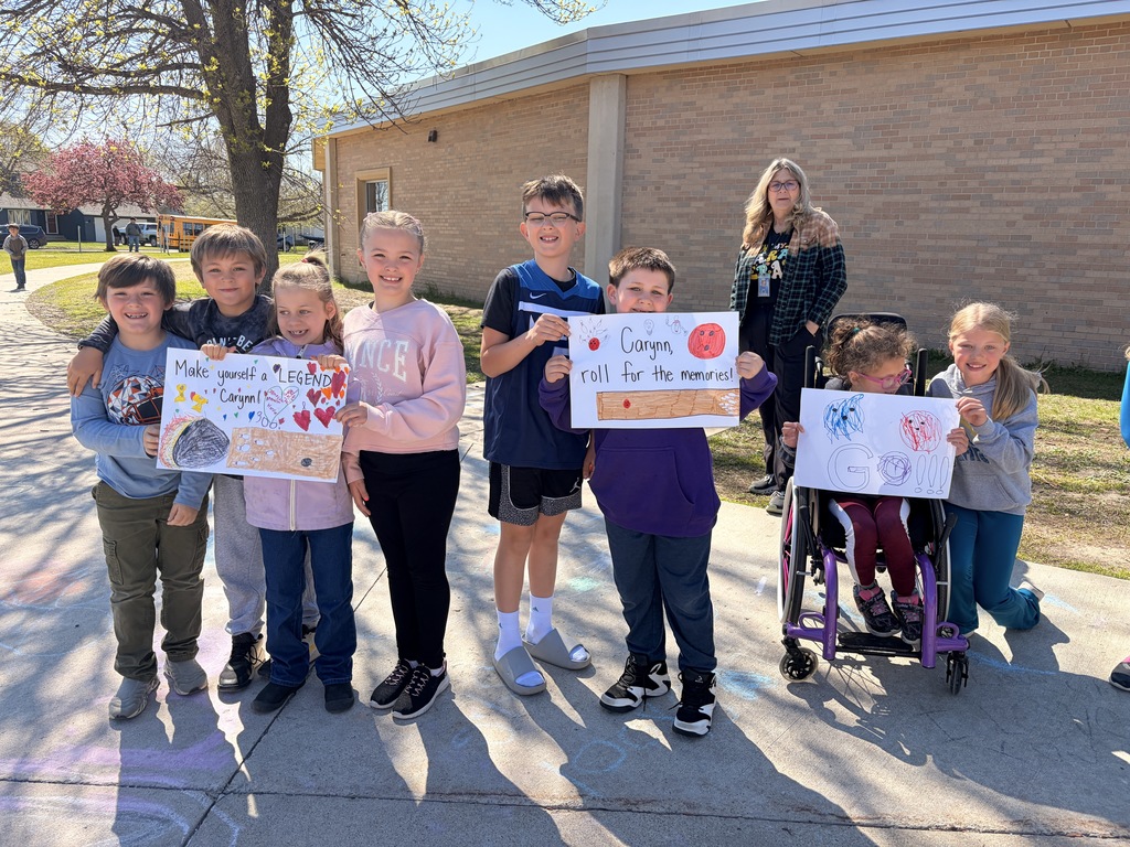 Students holding tassles and signs that say good luck at state. 