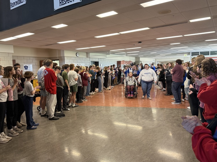 students lined up in two lines while bowling students walk through the middle of them  