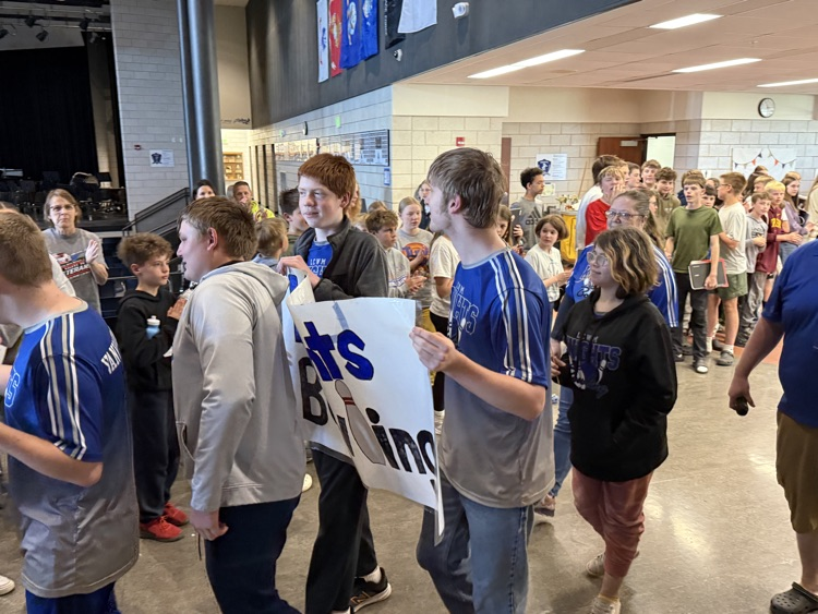 students lined up in two lines while bowling students walk through the middle of them. 