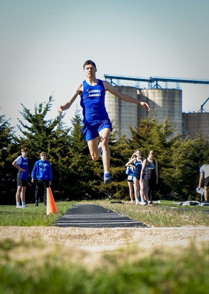 student running and leaping the triple jump run.
