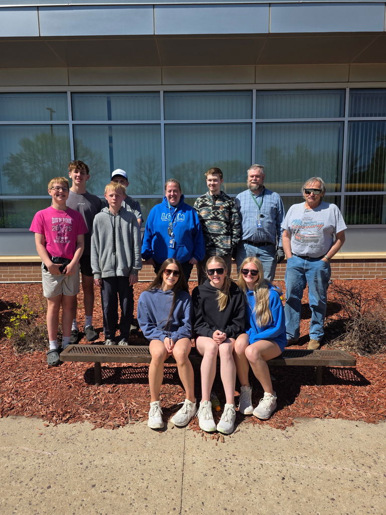Students sitting on a bench in front of the elementary.