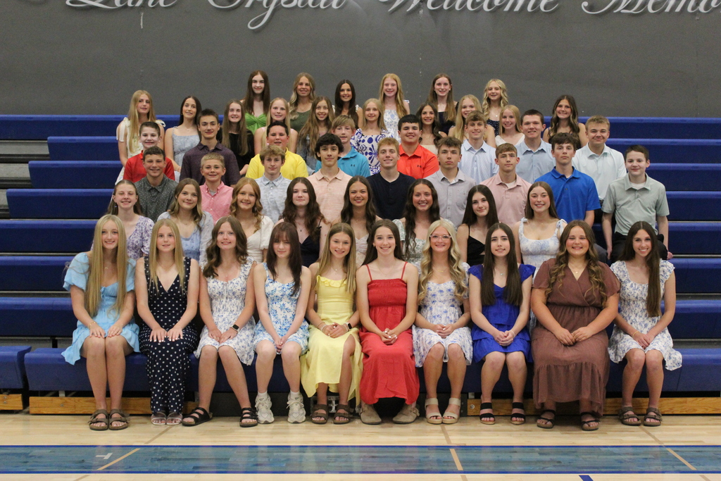 Group photo of students sitting in bleachers lined up in six rows, all just standing/sitting and looking at the camera.