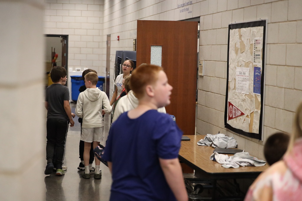 students walking down hall and looking into classrooms.