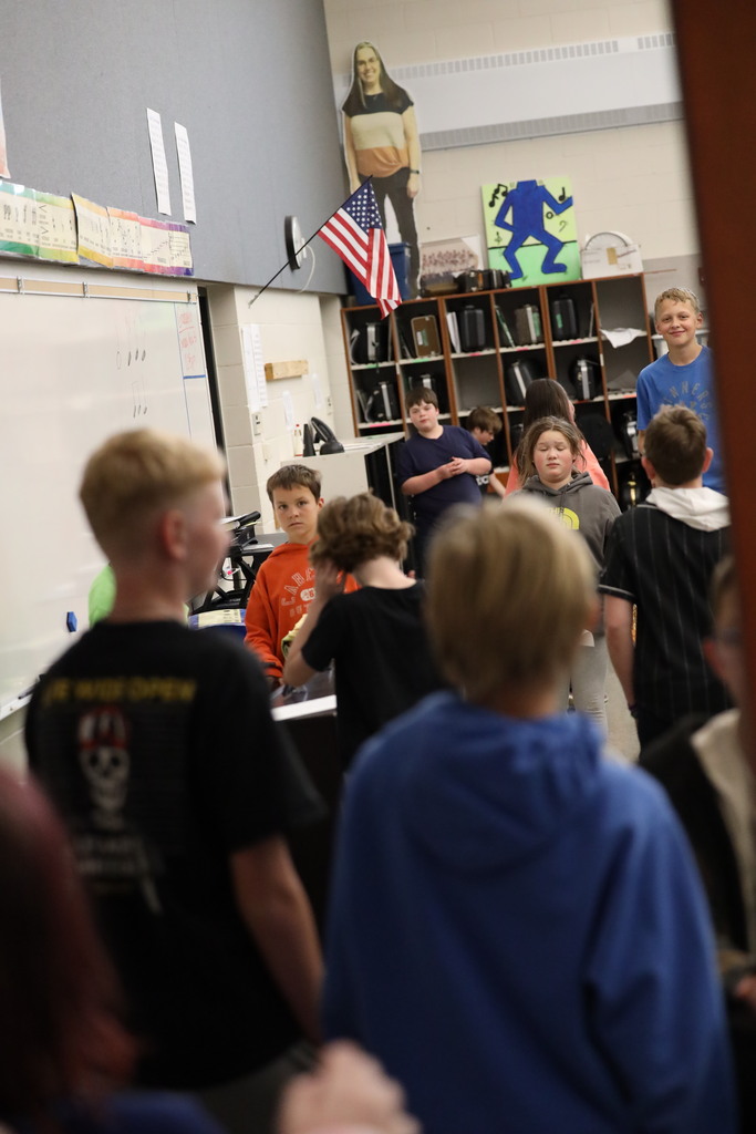 students walking down hall and looking into classrooms.