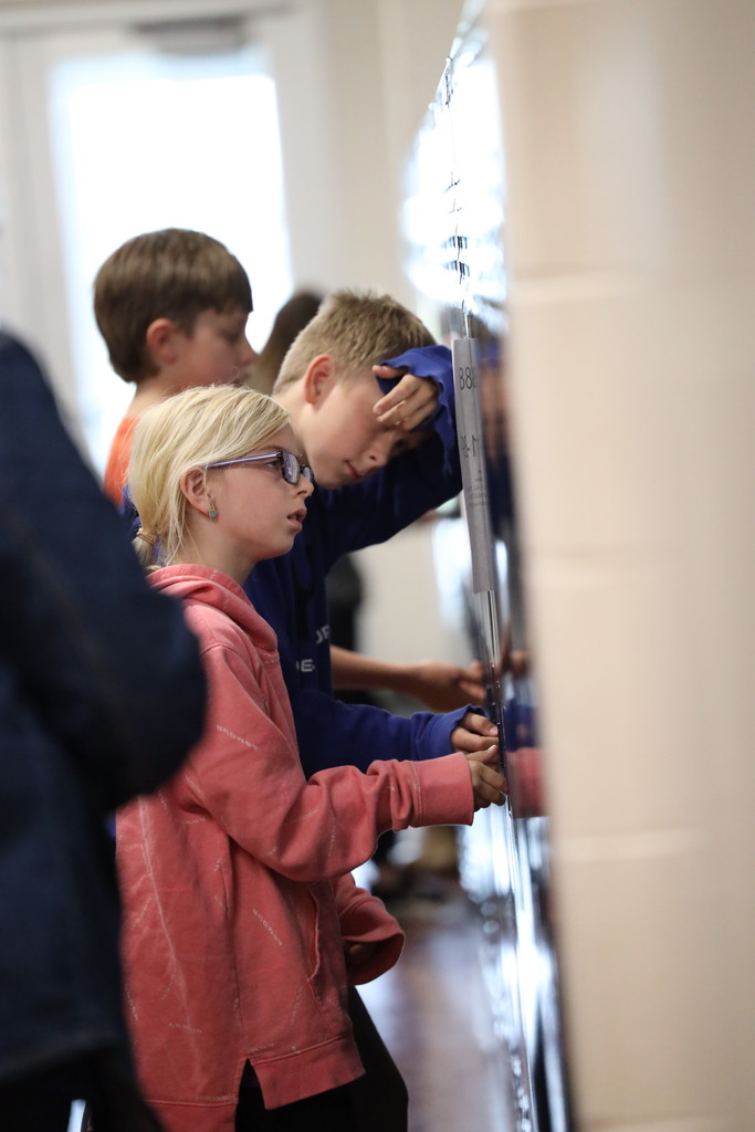 Students walking down and looking into classrooms.