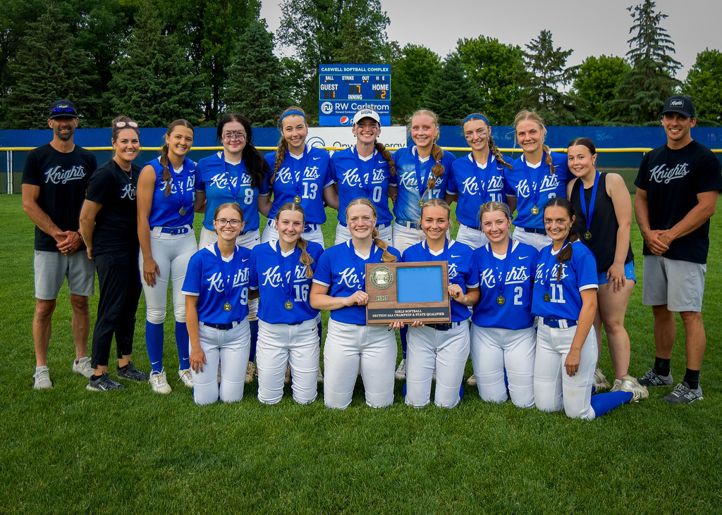 Team lined up in two rows holding trophy.
